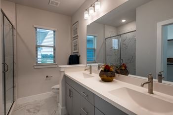 a bathroom with a large mirror and a sink and a shower